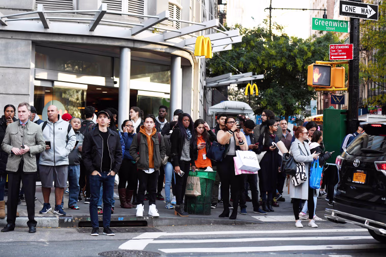 Image: A crowd watches as polioce investigte a shooting in downtown New YOrk