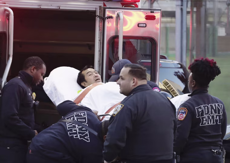 Image: Emergency personnel carry a man into an ambulance
