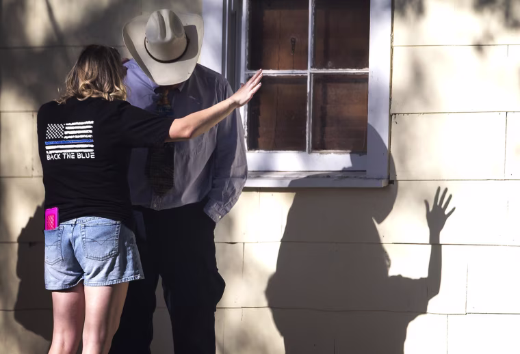 Image: A woman prays with a man after a fatal shooting