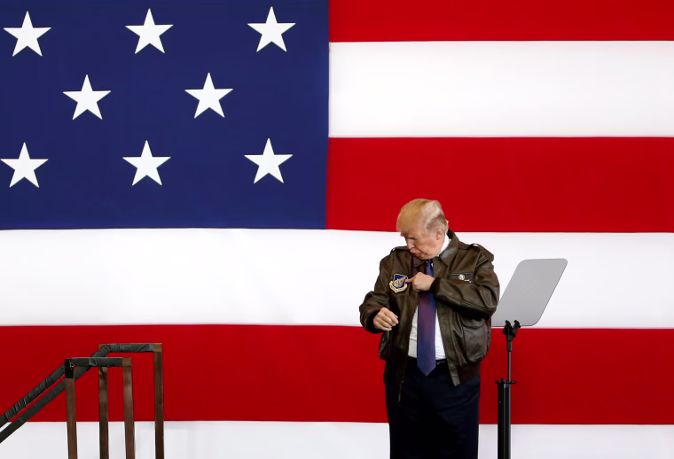 Image: President Trump points to a detail on his flight jacket while on stage at U.S. Air Force Yokota Air Base.