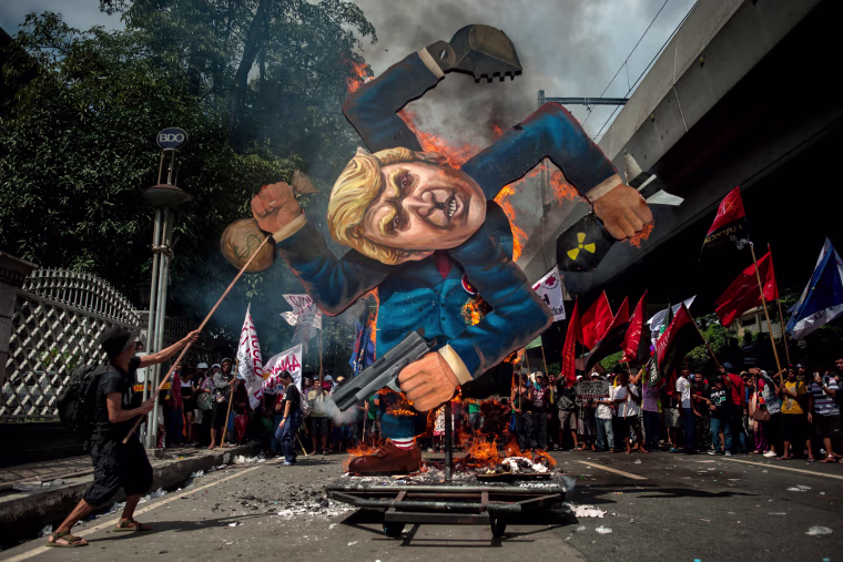 Image: Protesters burn an image of Trump fashioned on a swastika as they march the streets of Manila during the start of the ASEAN meetings between heads of state on Nov. 13.