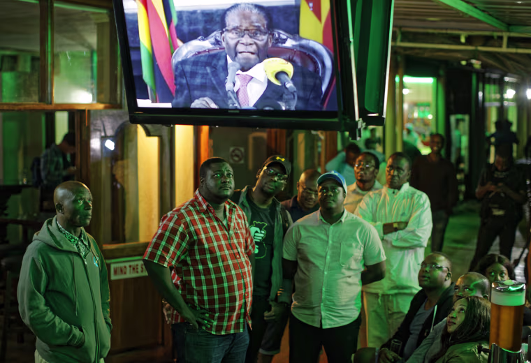 Image: Zimbabweans watch a televised address to the nation by President Robert Mugabe at a bar