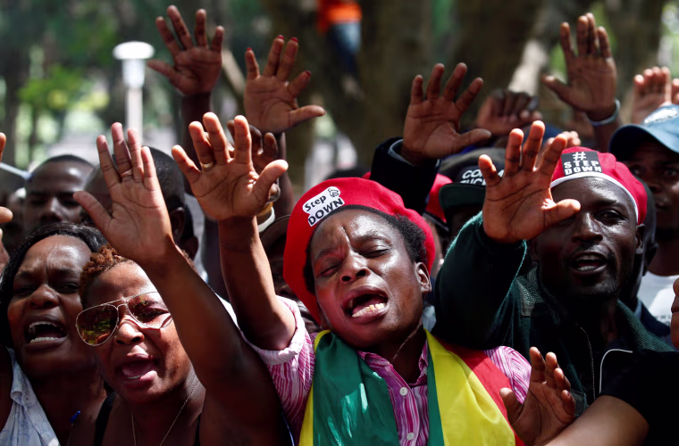 Image: Protesters calling for Zimbabwean President Robert Mugabe to resign attend a prayer meeting outside parliament in Harare