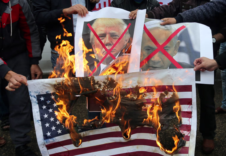 Image: Palestinians burn posters depicting Netanyahu and Trump during a protest against the U.S. intention to move its embassy to Jerusalem and to recognize the city of Jerusalem as the capital of Israel, in Rafah in the southern Gaza Strip