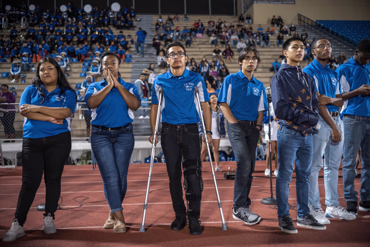 Image: Members of C.E. King's choir watch the team come onto the field