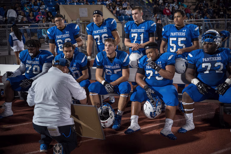 Image: C.E. King linemen take instruction on the field during the game