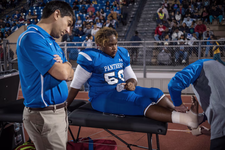 Image: C.E. King's Rashad Wright is treated for an injury during the game