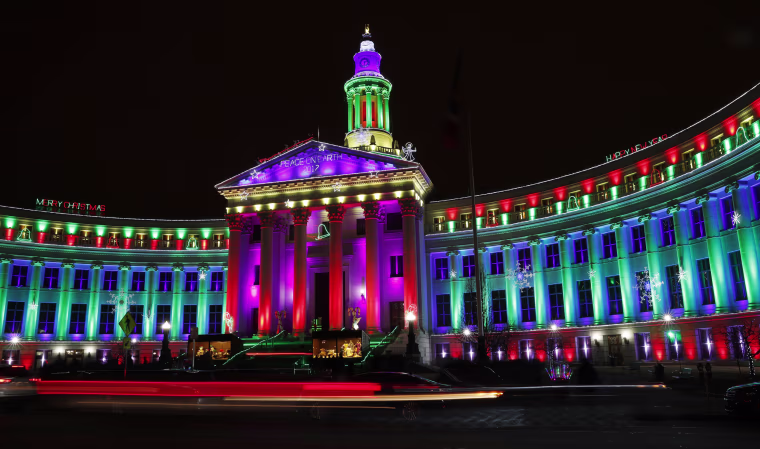 Image: Motorists pass the traditional holiday light display illuminates the Denver City/County Building