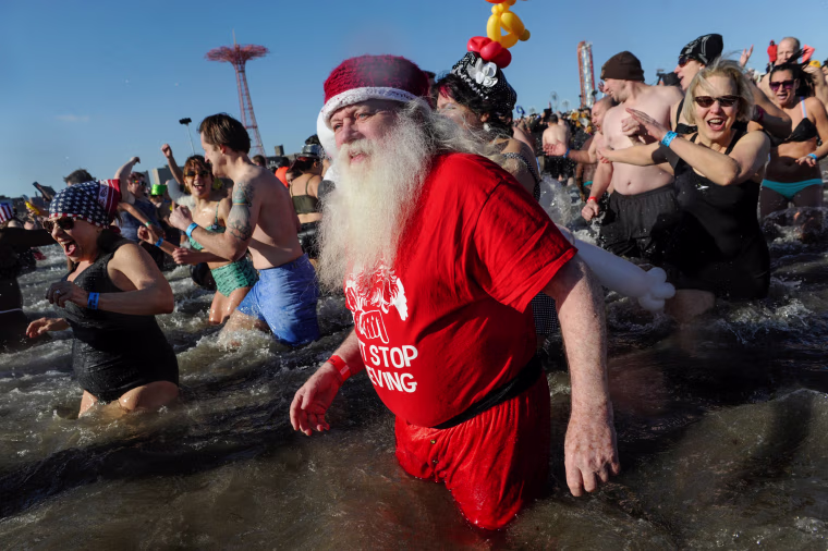 Image: A man dressed as Santa Claus participates in the annual Polar Bear Plunge in Coney Island in the Brooklyn Borough of New York City