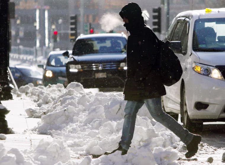 Image: A pedestrian crosses the street as the temperature hovers in the single-digits