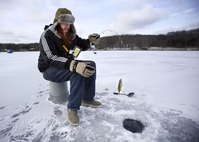 Image: Brendan Rancier, of New York City, pulls a pumpkinseed sunfish from Lackawanna Lake