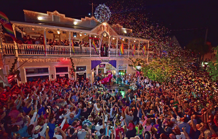 Image: Revelers celebrate as female impersonator Gary Marion is lowered during the Red Shoe Drop, at Duval Street in Key West, Florida