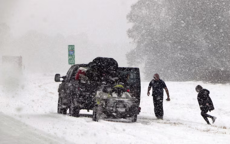 Image: People attend to their vehicle on Interstate 26, near Savannah
