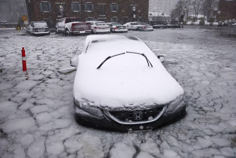 Image: A car sits in floodwaters from Boston Harbor on Long Wharf