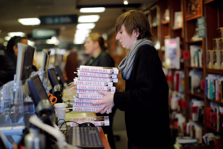 Image: An employee holds copies of the book "Fire and Fury: Inside the Trump White House"