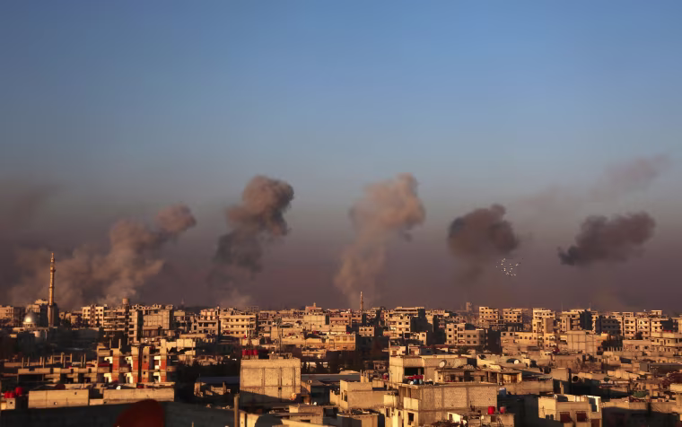 Image: Smoke rises from buildings following air strikes in Arbin
