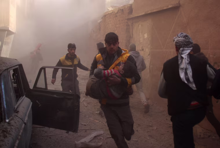 Image: Members of the Syrian civil defence evacuate wounded people