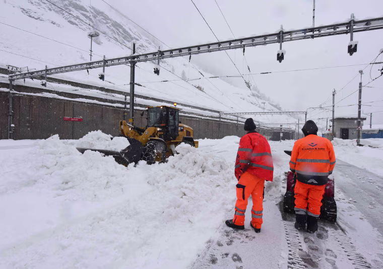 Image: Workers attempt to clear snow from the railway tracks at the Zermatt train station