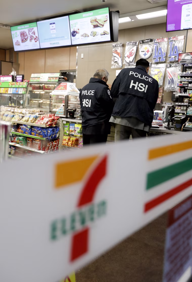 Image: U.S. Immigration and Customs Enforcement agents serve an employment audit notice at a 7-Eleven