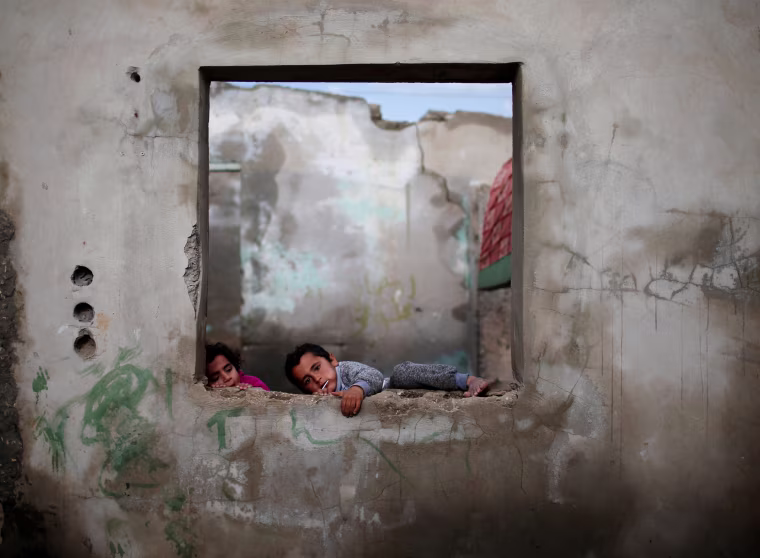 Image: Palestinian children play at their family's house in Al-Shati refugee camp in Gaza City