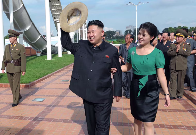 North Korean leader Kim Jong-un, center, accompanied by his wife Ri Sol Ju, right, waves to the crowd as they inspect the Rungna People's Pleasure Ground on July 25, 2012 in Pyongyang, North Korea.