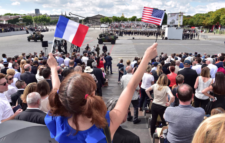 A girl waves the French and US flag during the annual Bastille Day military parade on the Champs-Elysees avenue in Paris on July 14, 2017. The parade on Paris's Champs-Elysees will commemorate the centenary of the US entering WWI and will feature horses, helicopters, planes and troops. / AFP PHOTO / CHRISTOPHE ARCHAMBAULTCHRISTOPHE ARCHAMBAULT/AFP/Getty Images