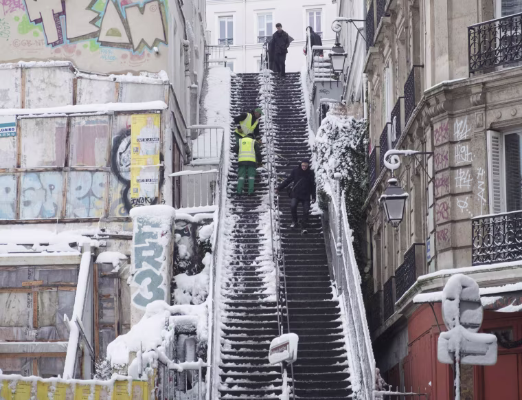 City employees clear snow from a staircase in Montmartre on Feb. 7.
