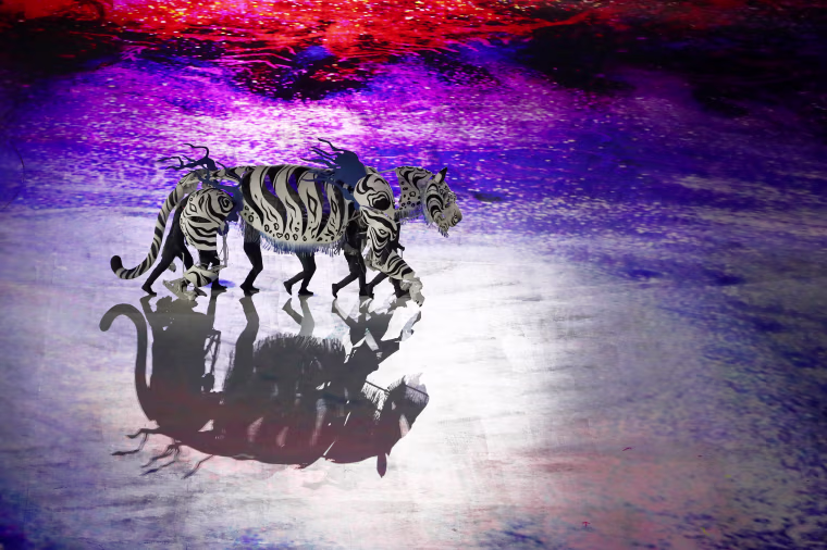 Performers move as a white tiger.