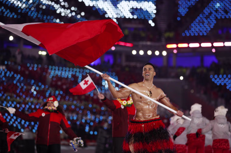 Pita Taufatofua carries the flag of Tonga.