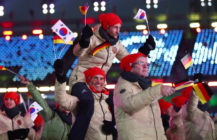 The German delegation waves South Korean and German flags.