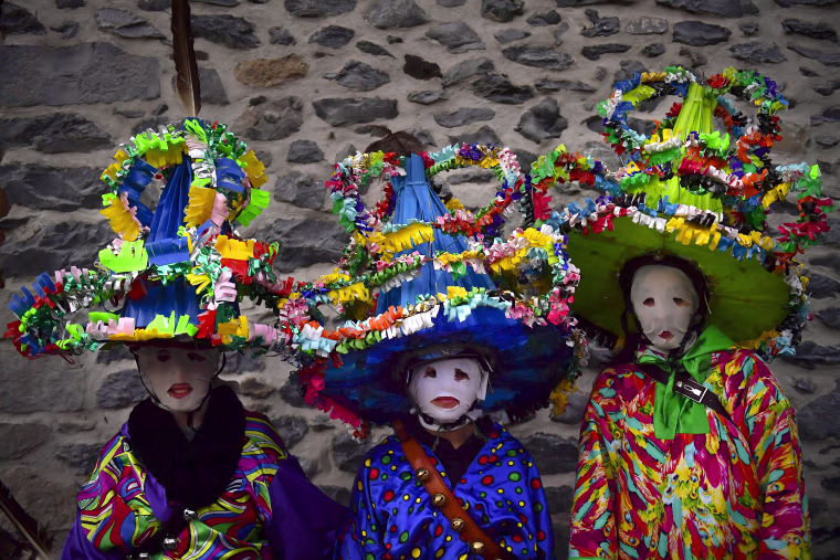 A group of participants dressed in traditional clothes and wearing large hats decorated with ribbons and feathers, known as ''Ttutturo'', take part in the Carnival of the Pyrenees villages of Leitza, northern Spain on Jan. 30, 2018.