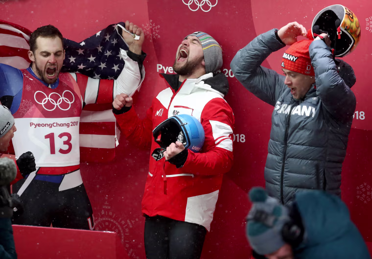 Chris Mazdzer (silver) of the U.S., David Gleirscher (gold) of Austria and Johannes Ludwig (bronze) of Germany celebrate following the luge men's singles competition on Feb. 11.