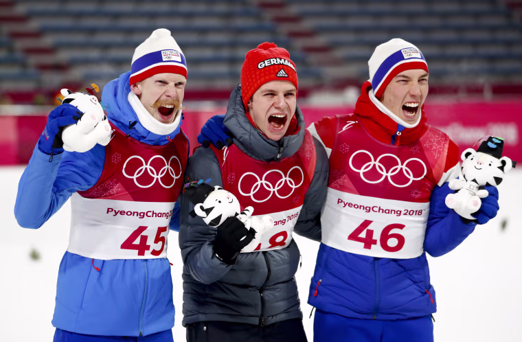 Gold medal winner Andreas Wellinger, of Germany, flanked by silver medal winner Johann Andre Forfang, of Norway, right, and bronze medal winner Robert Johansson, of Norway, pose after the men's normal hill individual ski jumping competition on Feb. 11.