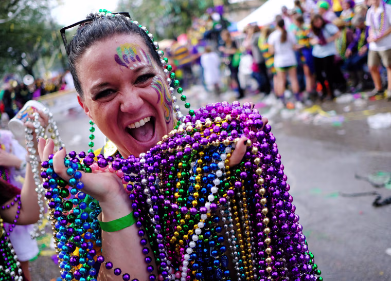 Karen Price shows off her catch of beads from the The Krewe of Thoth parade during Mardi Gras celebrations in New Orleans on Feb. 11, 2018.