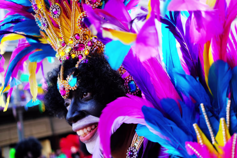Image: A foot marcher with the Krewe of Zulu makes his way down the street on Fat Tuesday