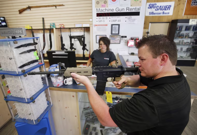 Image: An employee shows an AR-15 rifle to a customer