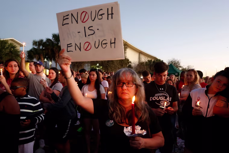 Mourners stand during a candlelight vigil.