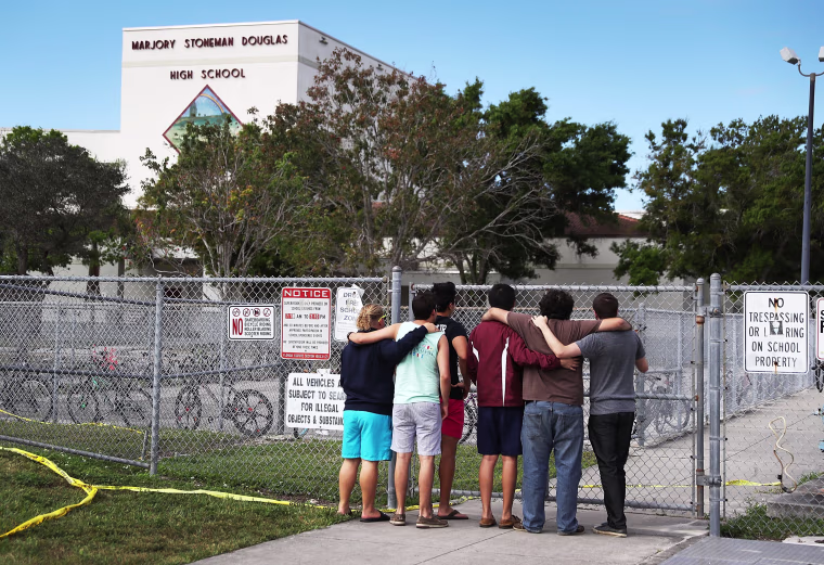 Image: People look on at the Marjory Stoneman Douglas High School