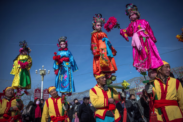Image: Chinese folk artists perform during a parade celebrating the upcoming Lantern Festival