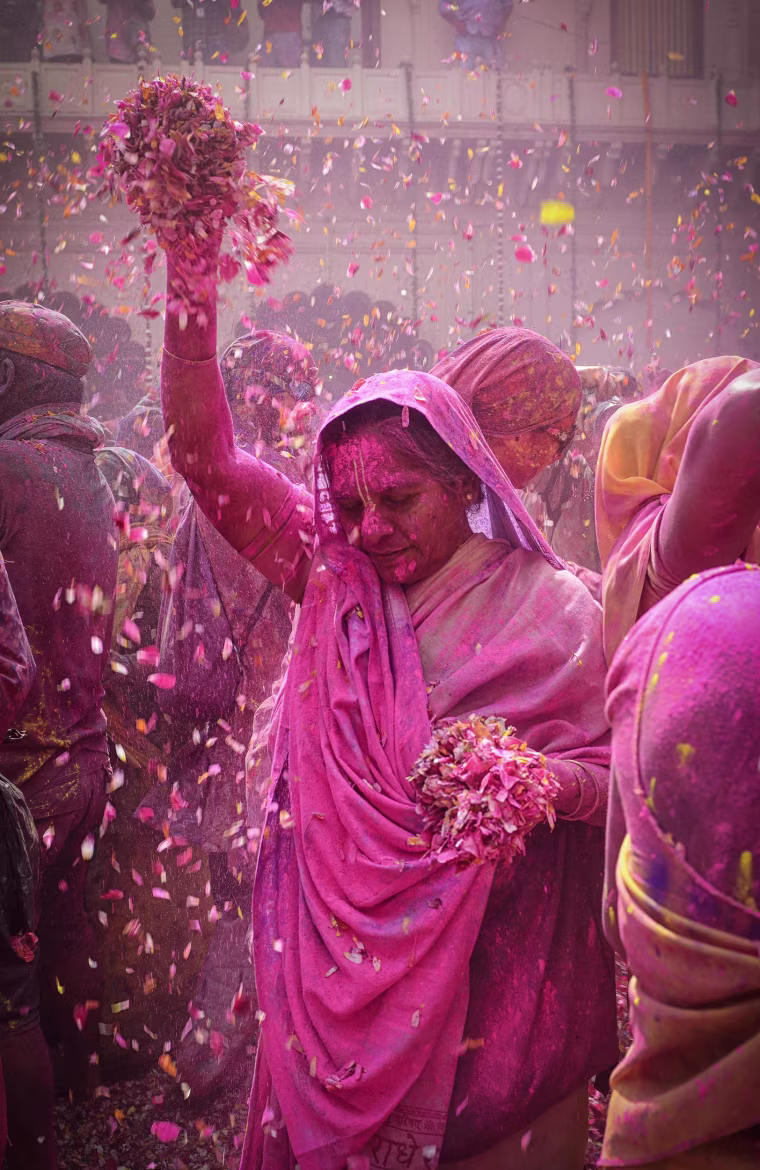 Image: An Indian widow dances covered in colored powder during Holi festival celebrations