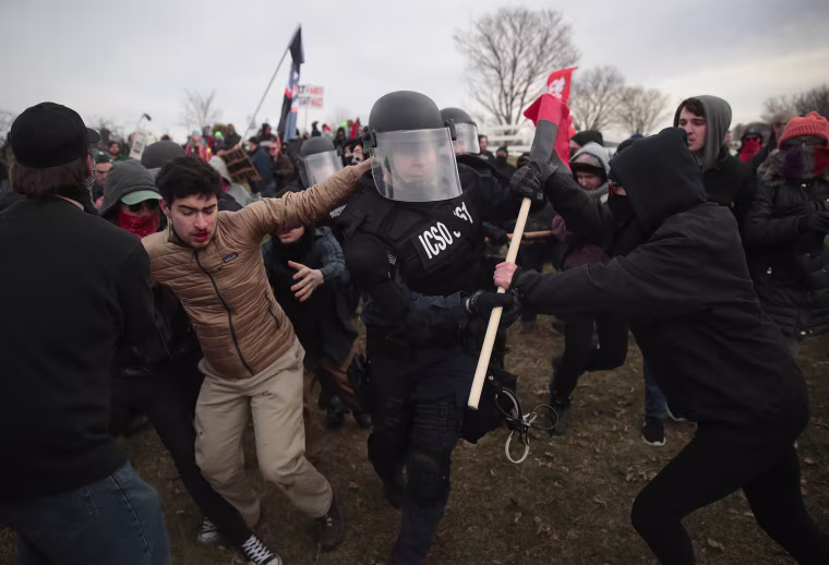 Image: Police clash with demonstrators as they escort people to a speech by white nationalist Richard Spencer at Michigan State University