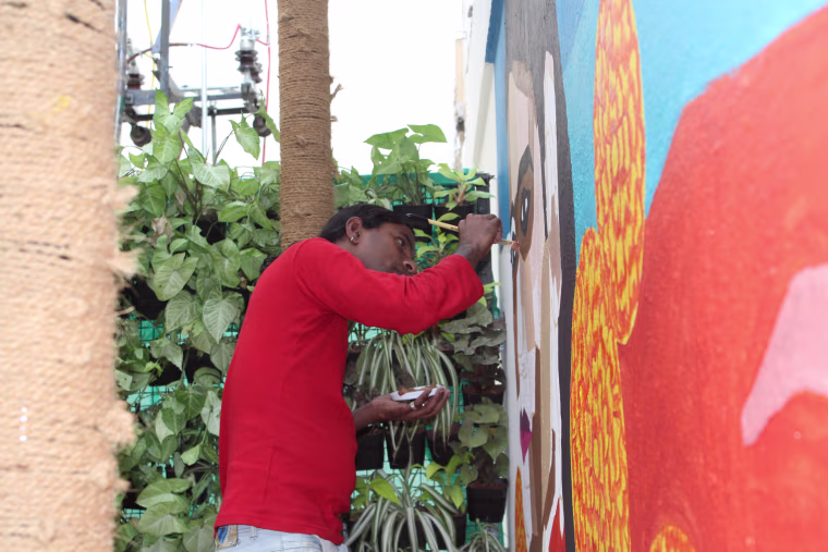 Purushi painting a mural in Bangalore, India, in March 2018.