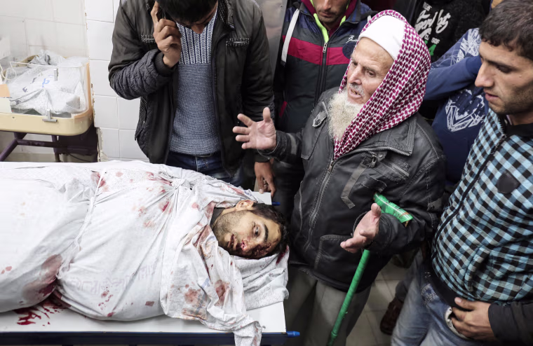 Relatives of 27-year-old Palestinian farmer Omar Samour, who was killed by Israeli tank fire before demonstrations even began, recite prayers as they stand above his body in the morgue of a hospital in Khan Yunis in the southern Gaza strip on March 30. Local witnesses said Samour was working his land near the border when the shells hit, while an Israeli army spokesman reported that \"two suspects approached the security fence along the southern Gaza Strip and began operating suspiciously.\" The shelling came just hours before the opening of the protest camps near the border, for which the Israeli army deployed reinforcements, including more than 100 special forces snipers, in fear of mass attempts to break through the security fence.