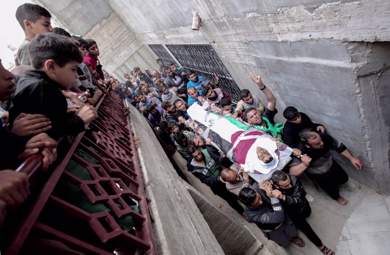 Palestinian mourners carry the body of Ibrahim Abu Shaer, who was killed on March 30 by Israeli forces, during his funeral in Rafah, in the southern Gaza Strip, on March 31.