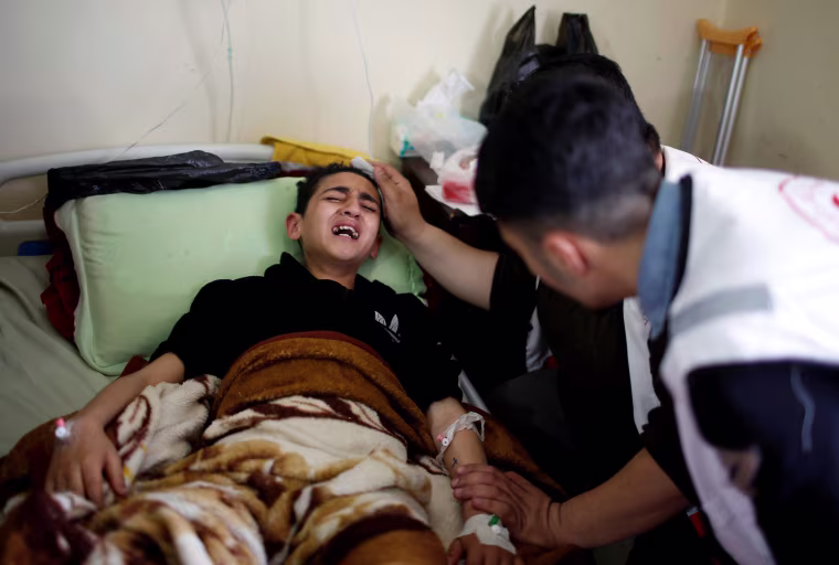A young Palestinian boy who was wounded in the clashes is surrounded by family at al-Shifa hospital in Gaza City on April 1.