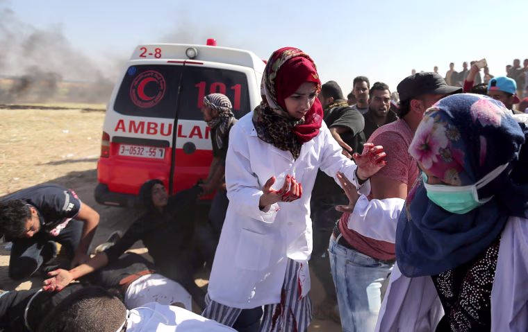 Female Palestinian medic Razan Al-Najar treats injured protesters who were wounded in clashes at the Israel-Gaza border, in the southern Gaza Strip on April 1.

Brig. Gen. Ronen Manelis, the chief army spokesman, denied allegations of excessive use of force, saying those killed by Israeli troops were men, aged from 18 to 30, who were involved in violence and belonged to militant factions.