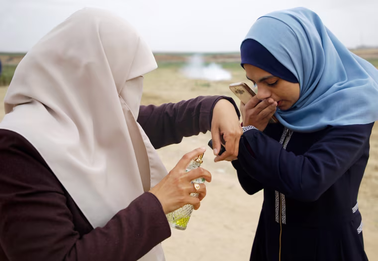 A Palestinian woman sprays perfume on the hand of her daughter to cover the smell of tear gas fired by Israeli forces during clashes along the border with Israel on April 3.

Tensions remained days after at least 19 Palestinians were killed by Israeli forces following a mass demonstration for the Palestinian Land Day commemoration on March 30.
