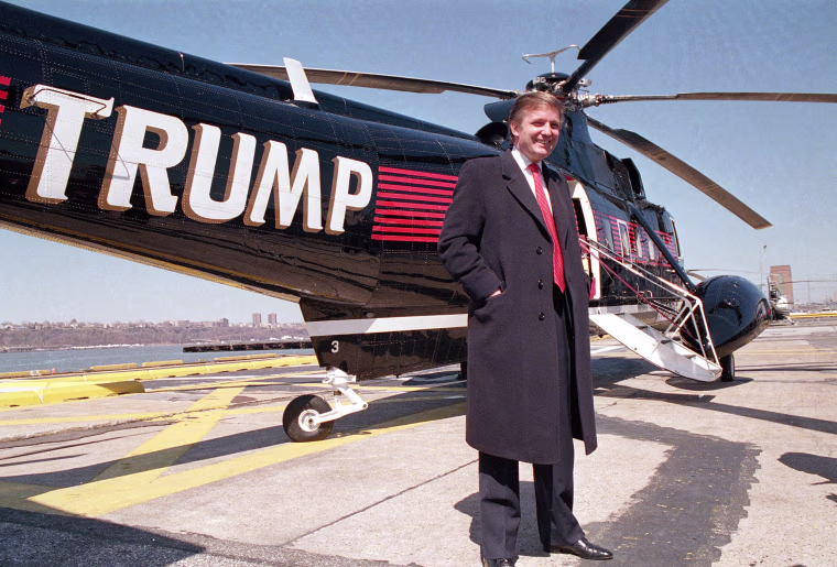 Image: Real estate magnate Donald Trump poses in front of one of three Sikorsky helicopters