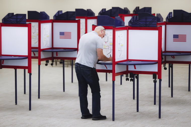 Image: A voter fills out a ballot on the first day of early voting at the Hamilton County Board of Elections
