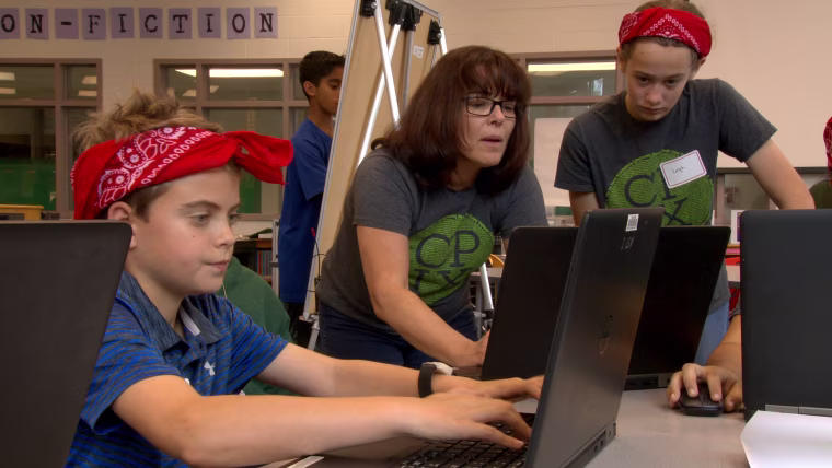 CyberPatriot competitors James Henry and Leigh Black with their coach Susie Suchodolski at Kilmer Middle School in Vienna, Virginia.